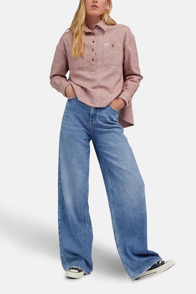 Lichtblauwe denim Stella A-lijn jeans van Lee®, met wijde pijpen en zwarte schoenen.