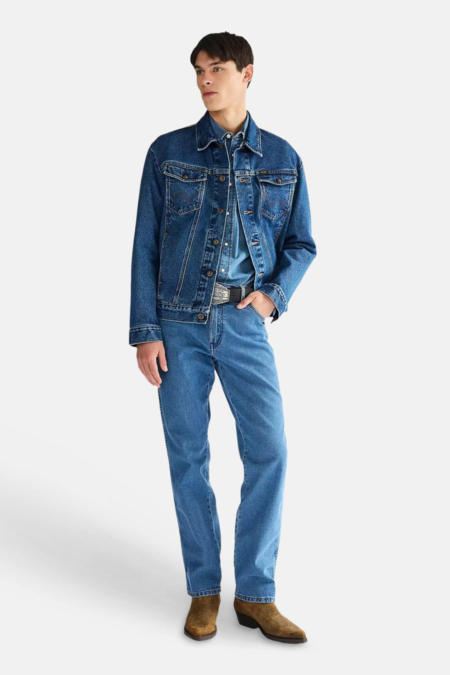 Middelblauwe rechte jeans van denim van Wrangler, gedragen door een man met een denim jack en bruine laarzen.