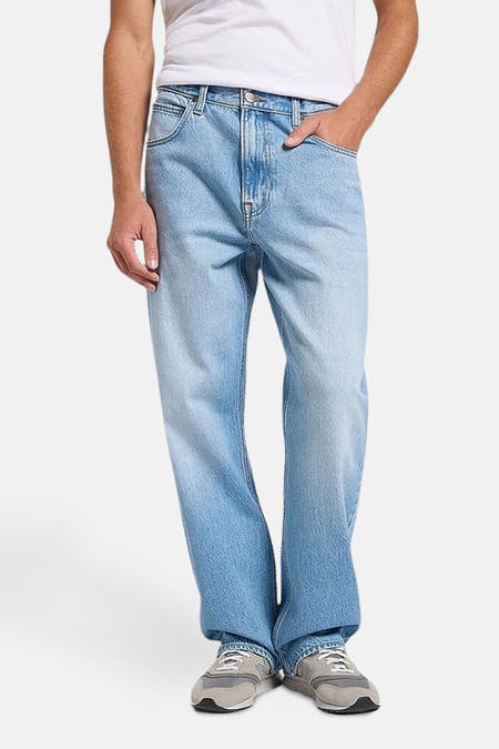 Wijde jeans van lichtblauwe denim van Lee, met een losse pasvorm en grijze sneakers.
