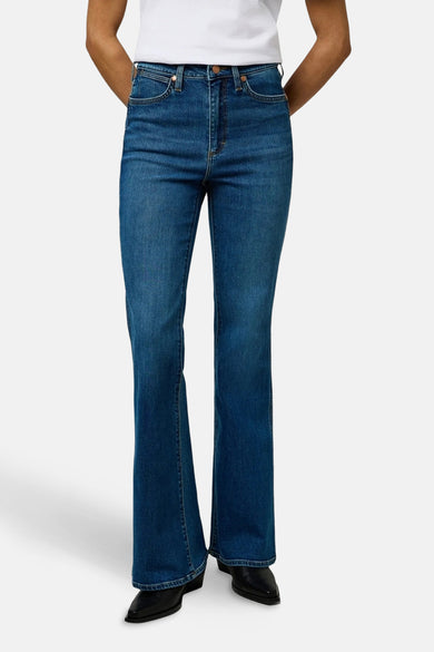 Mid blue denim flared jeans van Wrangler®, met hoge taille en zwarte schoenen.

