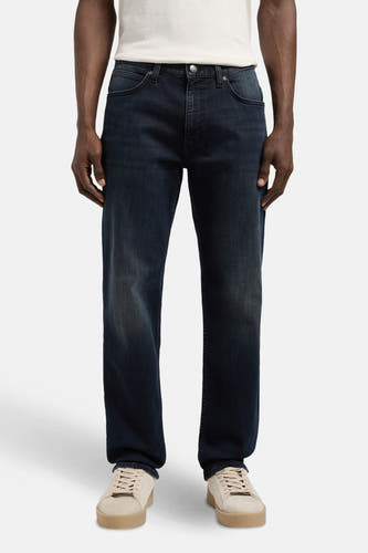 Jean droit en denim bleu de Lee, avec un léger lavage et des chaussures beige.