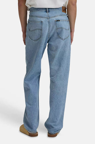 Wide lichtblauwe denim jeans van Lee, achterzakken met stiksels, leren taillebandlabel, gedragen met bruine clogs.
