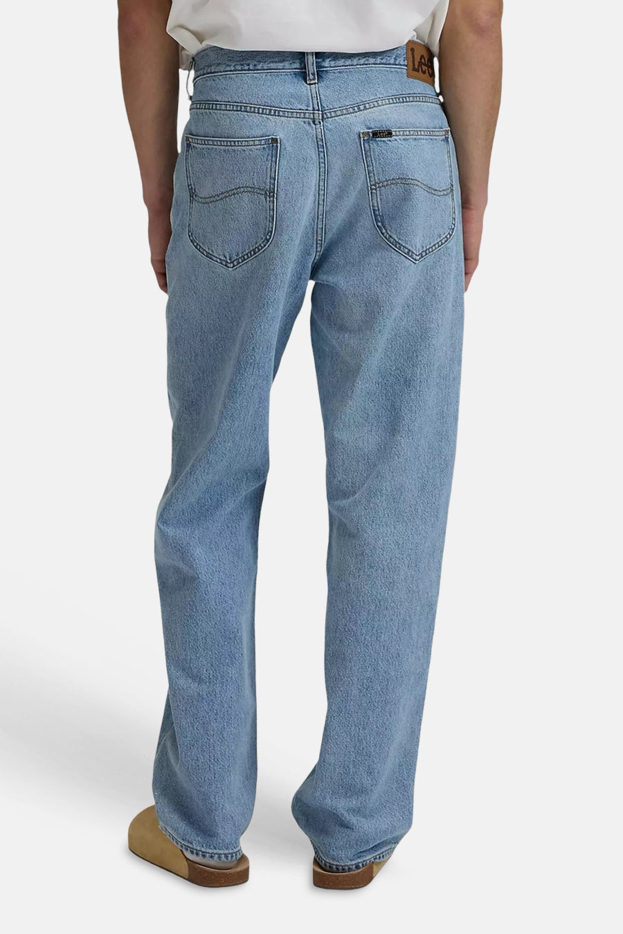 Wide lichtblauwe denim jeans van Lee, achterzakken met stiksels, leren taillebandlabel, gedragen met bruine clogs.