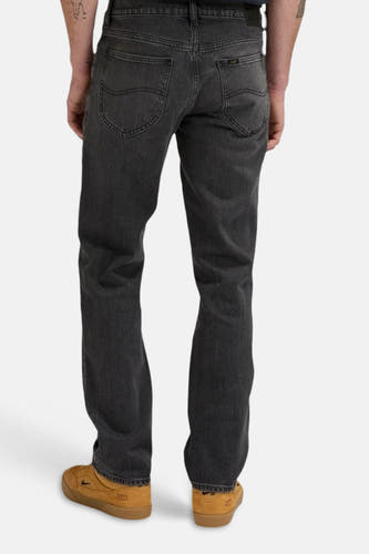 Donkergrijze straight jeans van Lee® met achterzakken en bruine schoenen.
