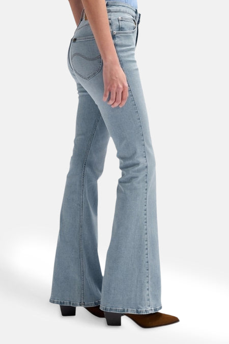 Lichtblauwe flared jeans van Lee, met zichtbare stiksels en gecombineerd met bruine schoenen.
