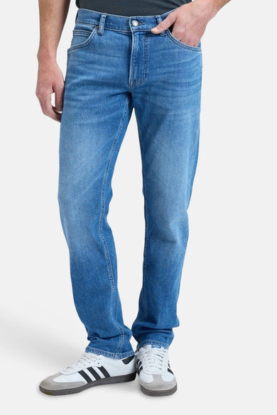 Blauwe rechte jeans van Lee®, met subtiele wassing en gedragen met witte sneakers.
