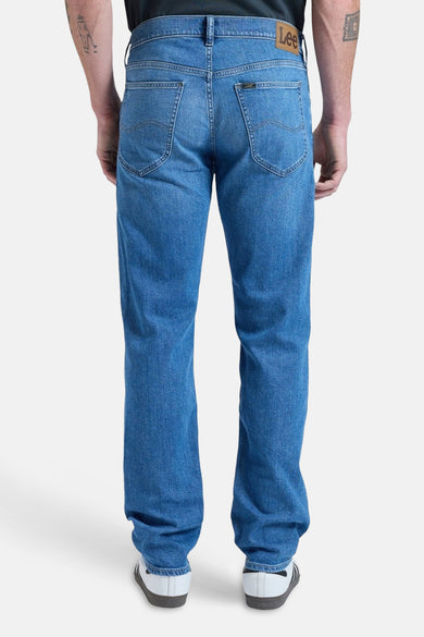 Blauwe rechte jeans van Lee, met achterzakken en witte schoenen.
