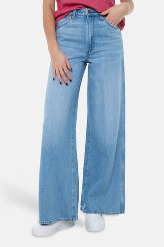 Lichtblauwe wide jeans van denim van Wrangler, gedragen met een rood T-shirt en witte sneakers.