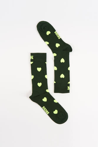 Groene sokken van Happy Socks, met gele hartjes en de tekst "Socks" erop, liggend op een witte achtergrond.