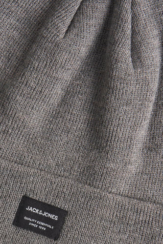 Grijze muts van ACCESSORIES BY JACK & JONES, met een fijne gebreide textuur en een zwart merklabel.
