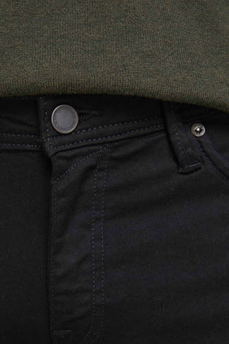 Jean slim noir de JACK & JONES JEANS INTELLIGENCE, avec détail de bouton et un haut vert.