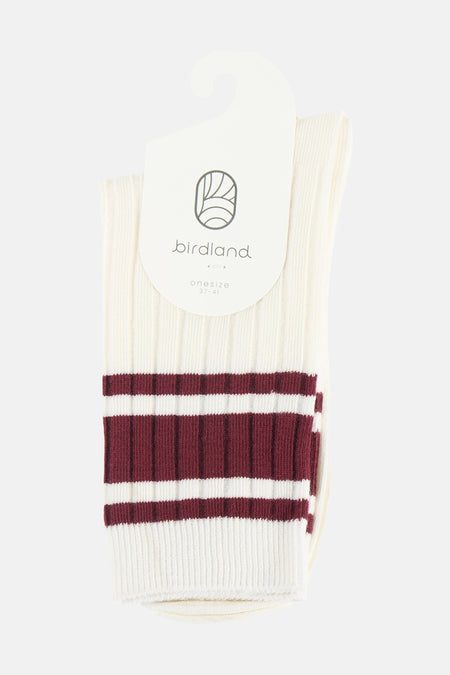 Roomwitte sokken van BIRDLAND met bordeauxrode strepen, ribbelstructuur en hangend aan een wit label.