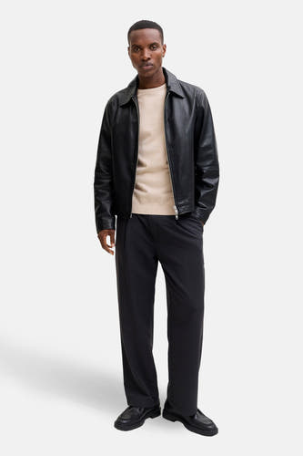 Beige trui met ronde hals van CORE BY JACK & JONES, gedragen met een zwarte leren jas en zwarte broek.