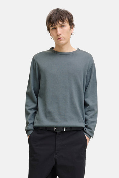 Sweat-shirt gris avec col rond de CORE BY JACK & JONES, porté avec un pantalon noir et une ceinture.