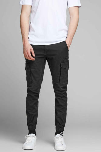 Zwarte cargobroek van JACK & JONES JEANS INTELLIGENCE, met opgestikte zakken en witte sneakers.
