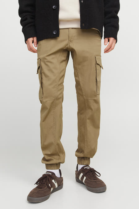 Jean cargo brun de JACK & JONES JEANS INTELLIGENCE, avec des poches sur les jambes et des chaussures brunes.