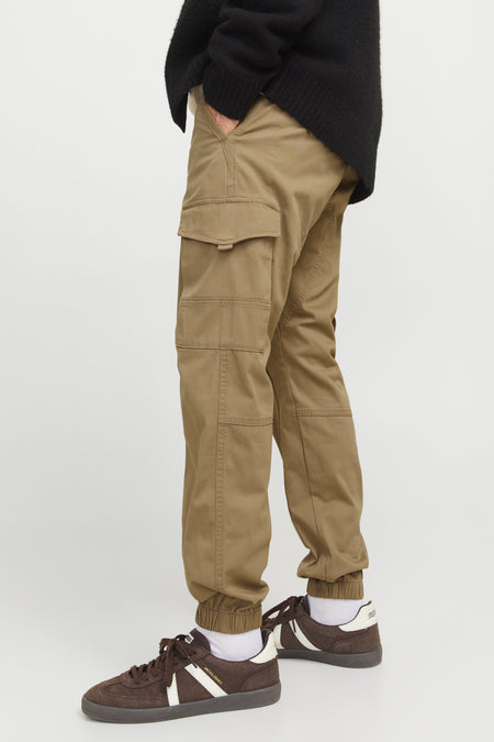 Pantalon de travail brun JACK & JONES JEANS INTELLIGENCE, avec des poches sur la jambe et des baskets brunes foncées.