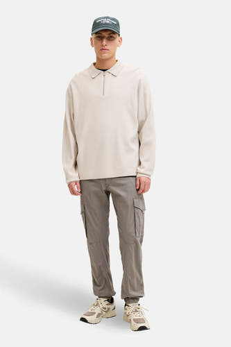 Bruine cargobroek van JACK & JONES JEANS INTELLIGENCE, met cargozakken en beige sneakers.
