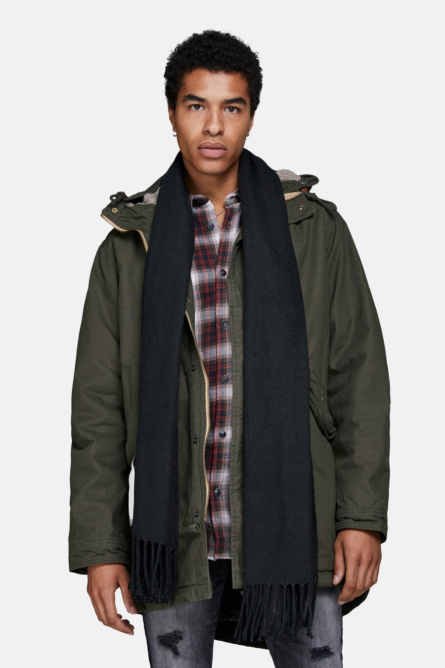 Zwarte wintersjaal van ACCESSORIES BY JACK & JONES, met franjes, gedragen met een geruit overhemd en een parka.
