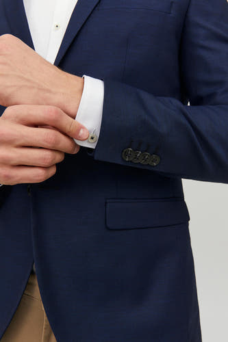 Blauwe blazer van PREMIUM by JACK & JONES, met knoopsluiting en een zak, gedragen over een wit overhemd.
