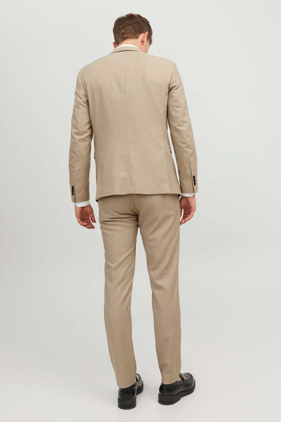 Beige blazer van PREMIUM by JACK & JONES, gezien van achteren, met bijpassende pantalon en zwarte schoenen.
