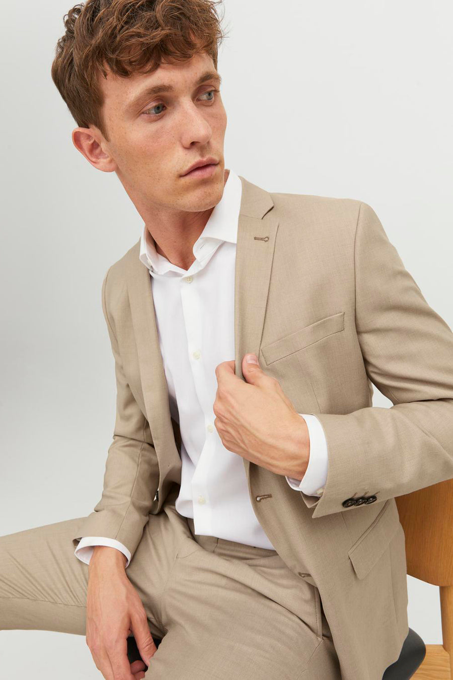Beige blazer van PREMIUM by JACK & JONES, gedragen over een wit overhemd en beige broek.