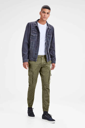 Groene cargobroek van JACK & JONES JEANS INTELLIGENCE, met zakken op de zijkanten, gecombineerd met een wit T-shirt en spijkerjas.