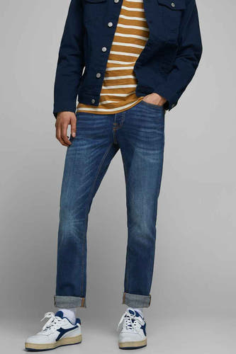 Slim fit jeans van denim door JACK & JONES JEANS INTELLIGENCE, in blauw, met opgerolde pijpen en witte sneakers.
