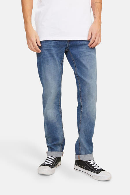 Slim fit jeans van JACK & JONES JEANS INTELLIGENCE in middenblauw denim, met opgerolde pijpen en sneakers.
