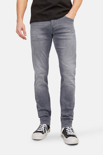 Jean slim de JACK & JONES JEANS INTELLIGENCE, en denim clair, avec des chaussures de toile noires.
