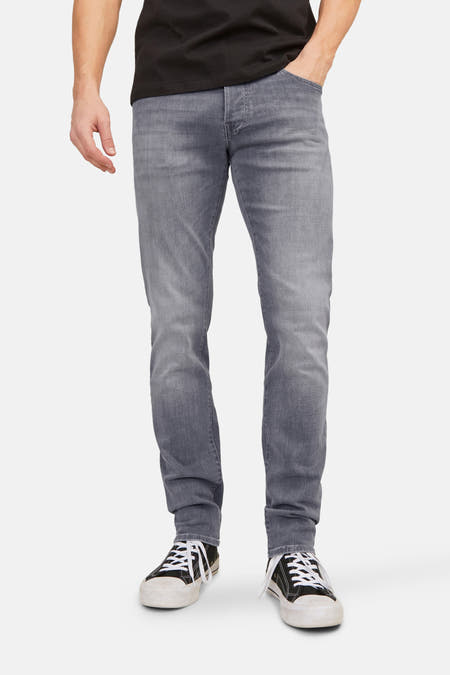 Slim fit jeans van JACK & JONES JEANS INTELLIGENCE, in lichtgrijs denim, met zwarte canvas schoenen.

