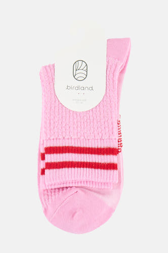 Roze sokken van BIRDLAND met een gebreide textuur, twee rode strepen en wit label.