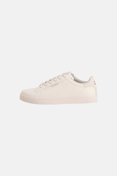 Witte sneakers van ACCESSORIES BY JACK & JONES met veters, een licht gestructureerd oppervlak en een lage snit, zijaanzicht.