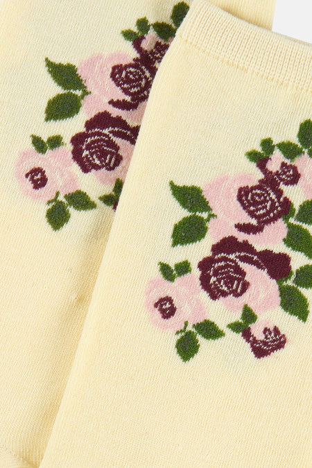 Crèmekleurige sokken van BIRDLAND met een ingebreid bloemenpatroon in roze, bordeaux en groen.