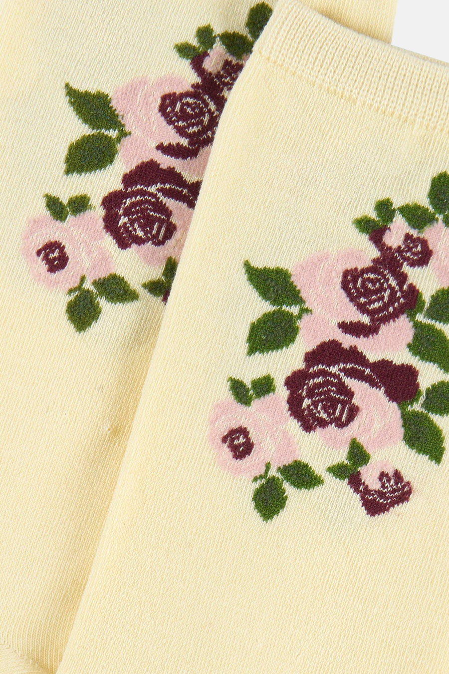 Crèmekleurige sokken van BIRDLAND met een ingebreid bloemenpatroon in roze, bordeaux en groen.