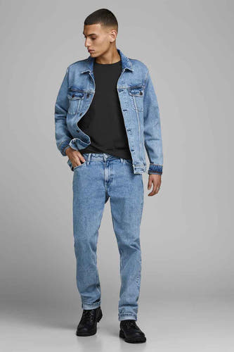 T-shirt noir de CORE BY JACK & JONES, porté sous un blouson en denim avec des jeans bleus et des bottes noires.