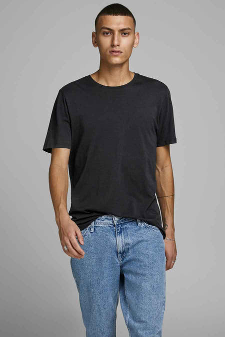 Zwart T-shirt van CORE BY JACK & JONES, gedragen met een blauwe jeans en zilveren ringen.