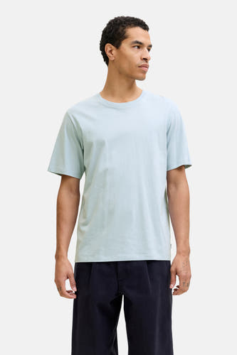 T-shirt bleu à manches courtes de CORE BY JACK & JONES, porté avec un pantalon foncé et des baskets légères.