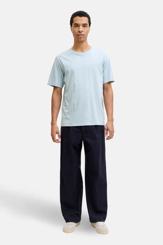 Blauw T-shirt met korte mouwen van CORE BY JACK & JONES, gedragen met een donkere broek en lichte sneakers.
