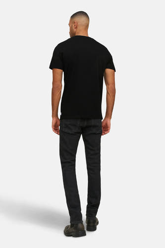 Zwart T-shirt van PREMIUM by JACK & JONES, achterkant gezien, met zwarte jeans en bruine laarzen.