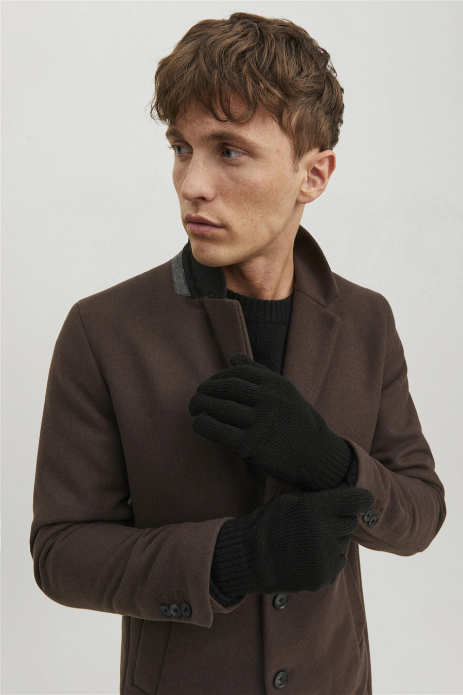 Gants de main noirs d'ACCESSORIES BY JACK & JONES, portés avec une veste en laine brune et un pull noir.