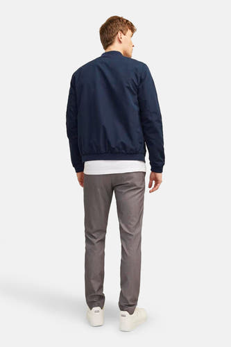 Blauwe korte jas van PREMIUM BLUE by JACK & JONES, achterkant gezien, gecombineerd met een witte top en grijze pantalon.