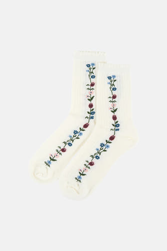 Twee witte sokken van BIRDLAND met verticale bloemenborduursels in blauw, roze, bordeaux en groen.