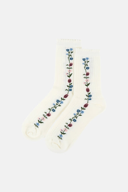 Twee witte sokken van BIRDLAND met verticale bloemenborduursels in blauw, roze, bordeaux en groen.