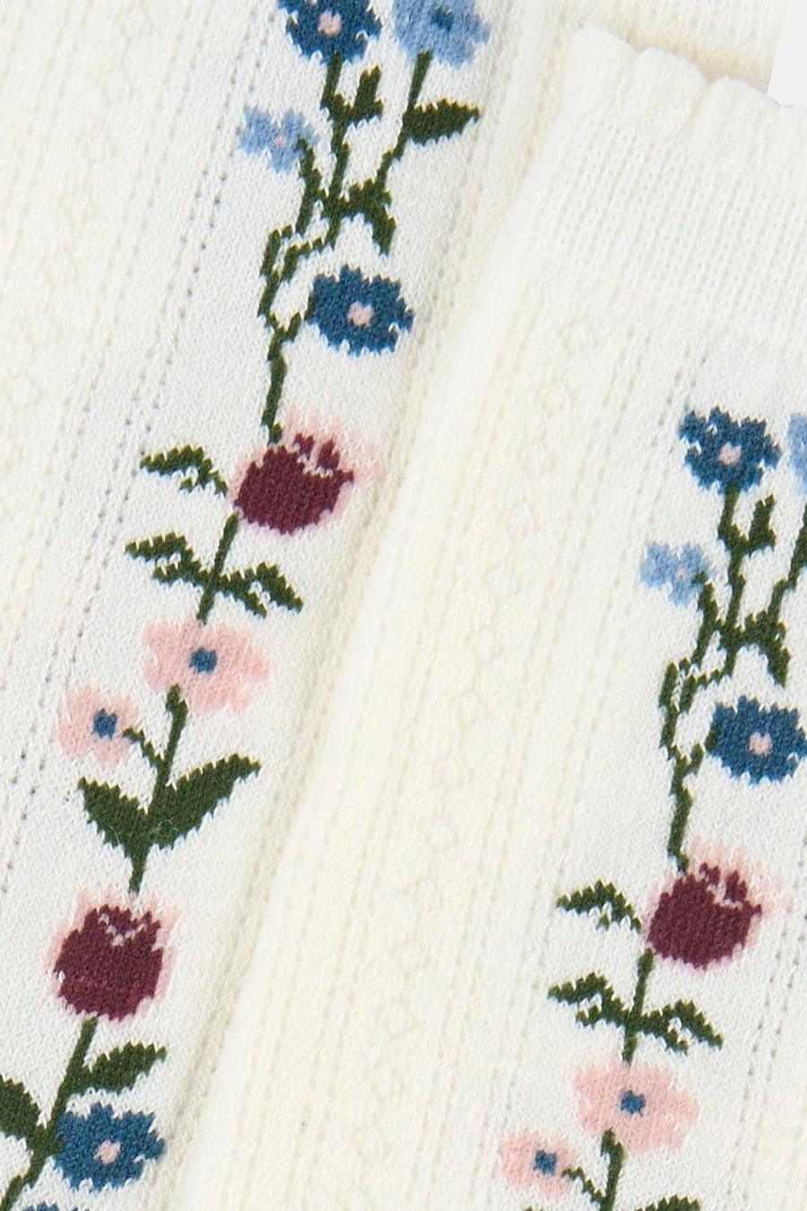 Witte sokken van BIRDLAND met een verticaal ingebreid bloemenpatroon in blauw, lichtblauw, roze en donkerrood.