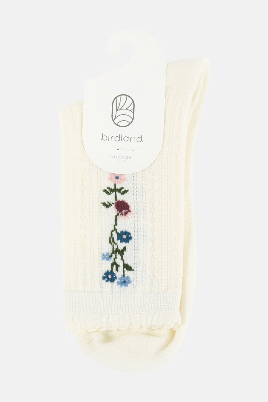 Crèmekleurige sokken van BIRDLAND met geborduurde bloemen, geribbelde textuur en ruches, aan een labelhanger.