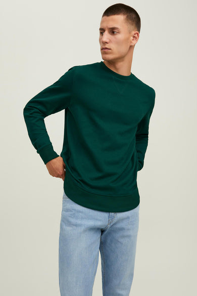 Donkergroene ronde hals sweater van ORIGINALS BY JACK & JONES, met ribboorden aan kraag, mouwen en zoom, gedragen met lichtblauwe jeans in lifestyle pose.