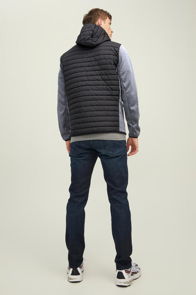Veste noire de CORE BY JACK & JONES, vue de dos avec des manches grises, associée à des jeans bleus foncés et des baskets.