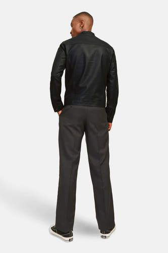Zwarte korte jas van CORE BY JACK & JONES, achterkant weergegeven, gecombineerd met grijze pantalon en zwarte sneakers.