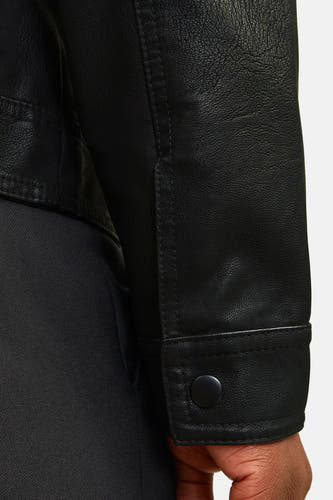 Zwarte jas van CORE BY JACK & JONES, met gladde textuur en detail van de knoopsluiting, zijaanzicht.
